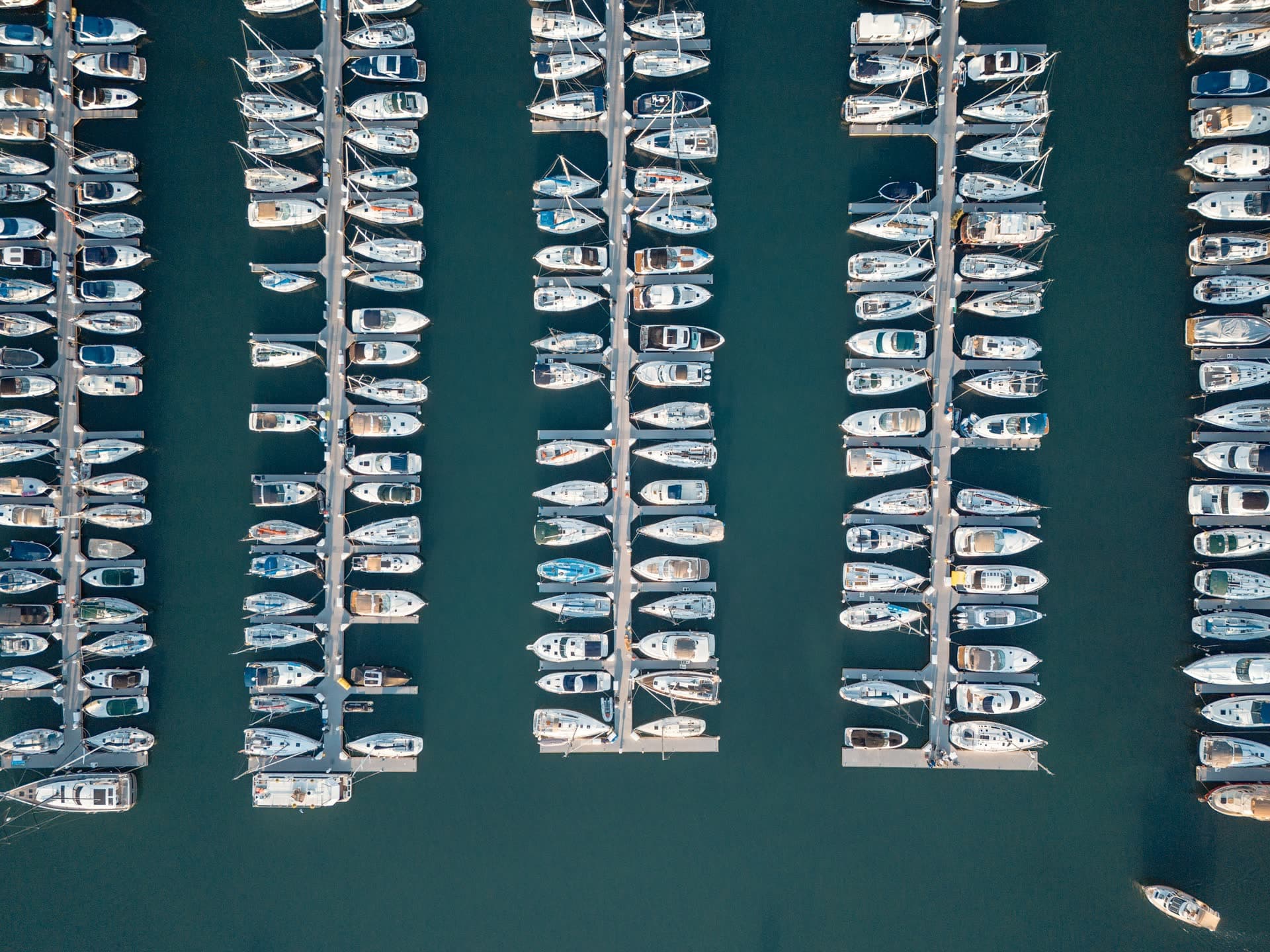 Aerial view of marina slips and boats on blue water
