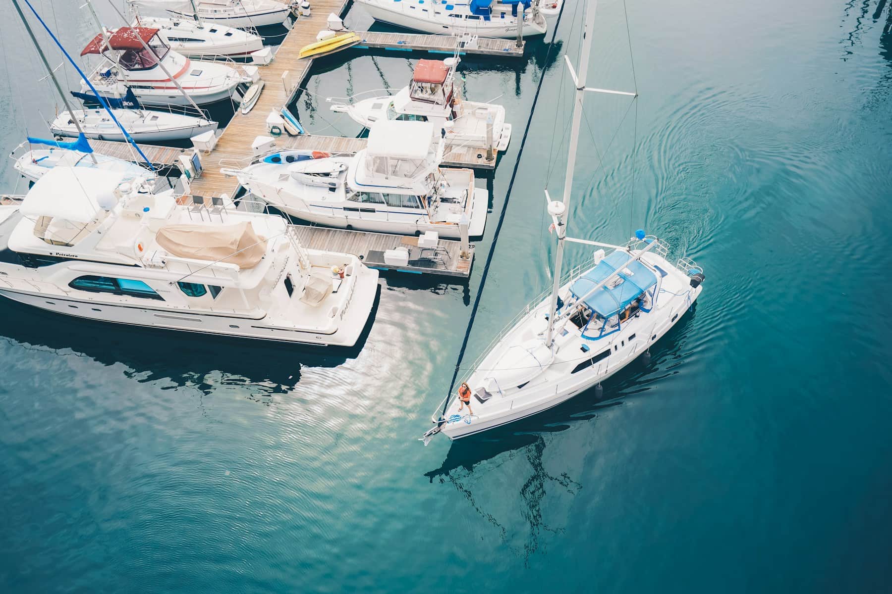 A sailboat arriving at a marina slip