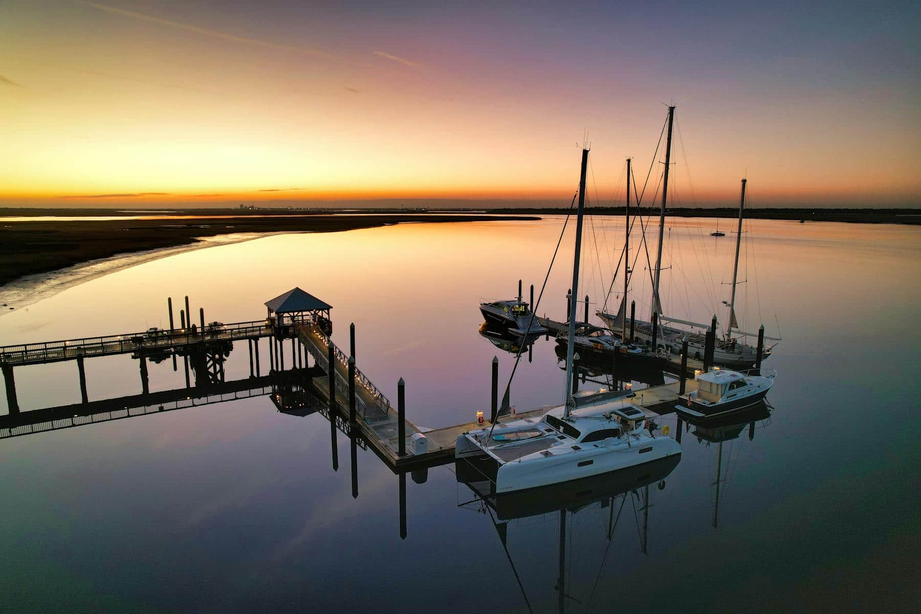 Sailboats at a marina dock during sunset