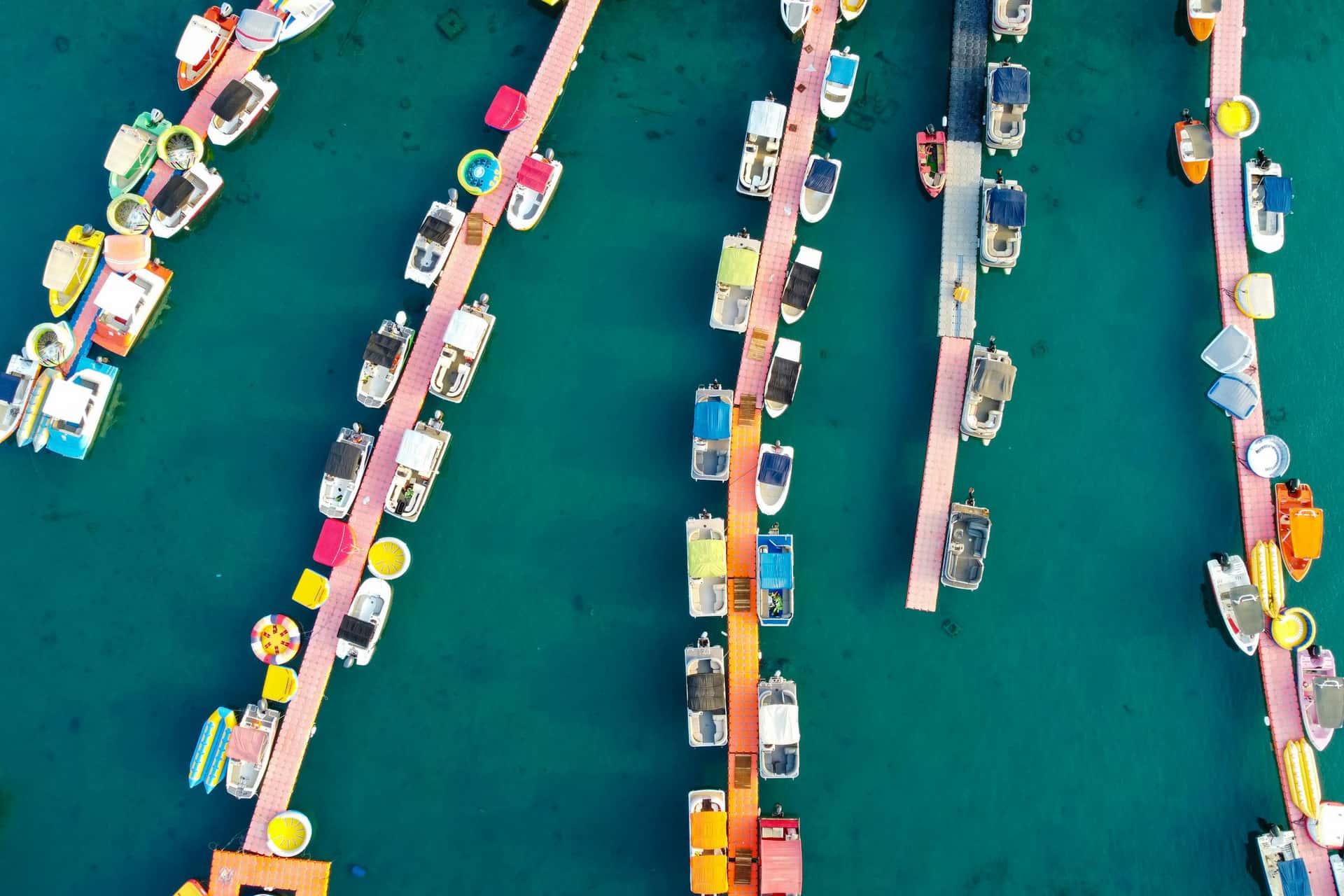 Colorful boats arranged in marina slips from above